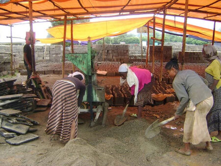 Kilkoro etiopskich pracowników pomaga na placu budowy nowej szkoły