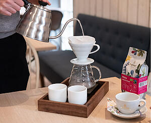 Hotelmitarbeiter bereitet frischen Dallmayr Filterkaffee mit Handfilter Zubehör zu