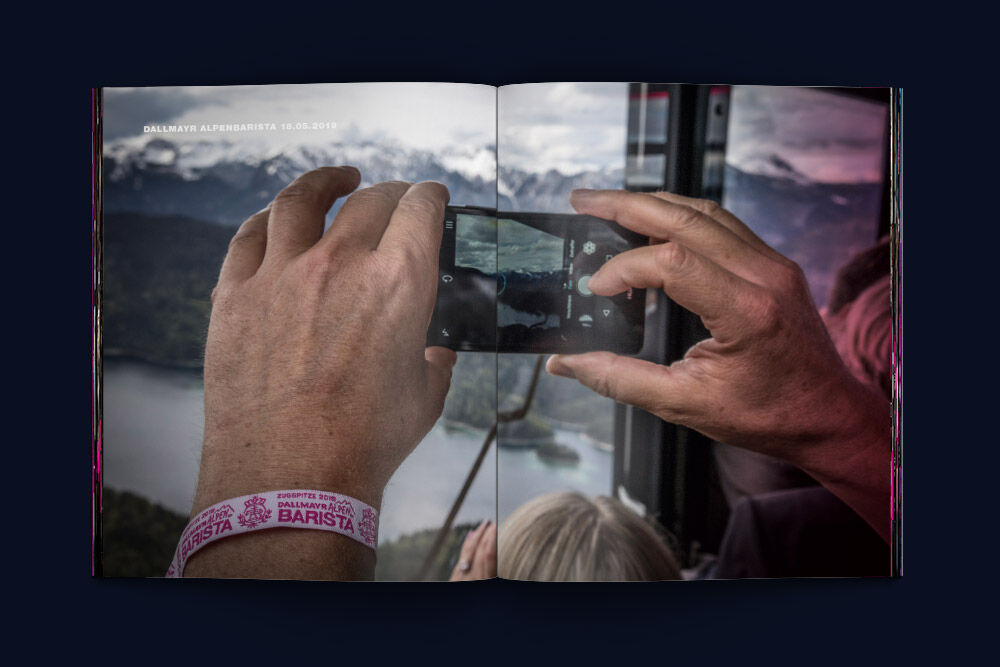 Mann fotografiert Aussicht auf Eibsee aus der Zugspitzbahn mit Smartphone