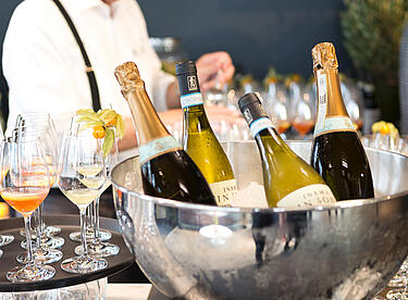 Champagner und Wein Flasche liegen in einem Kühler mit Eiswürfeln