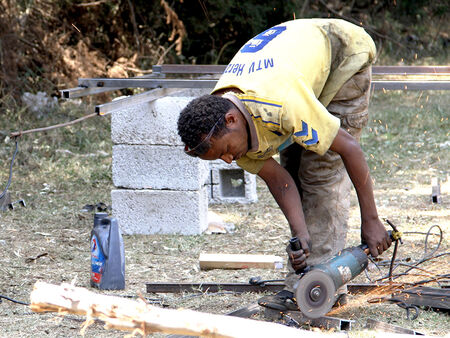 Etiopiešu strādnieks griež metāla stieņus