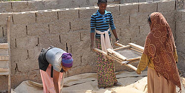 Trīs etiopiešu strādnieces palīdz būvlaukumā