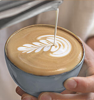 Ein Espresso, ein Caffè Crema und ein Cappuccino mit Latte Art werden präsentiert