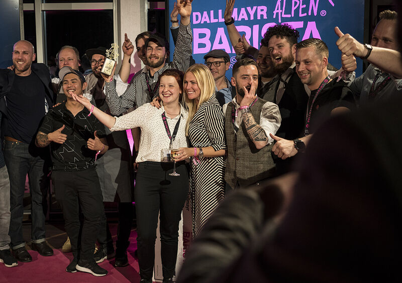 Teilnehmer und Gewinner des Dallmayr Alpenbarista jubeln auf der Bühne