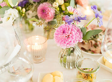 Hochzeits Tischdekoration mit rosanen Blumen und Kerzen