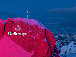 Pink angeleuchtete Zugspitze mit Dallmayr Logo