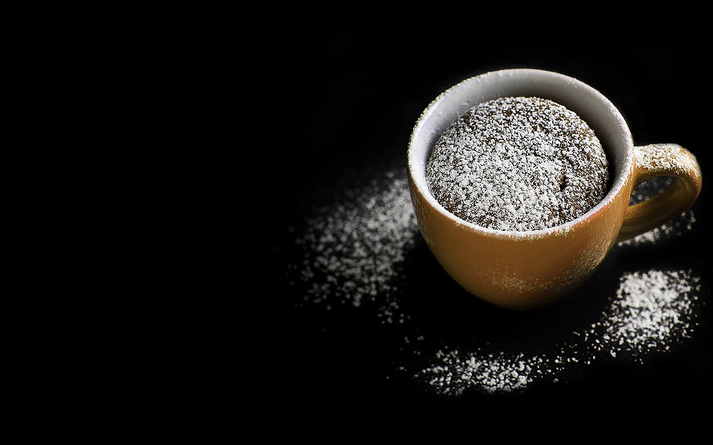 Dallmayr Schokoladen-Espressokuchen in einer gelben Espressotasse mit Puderzucker bestäubt