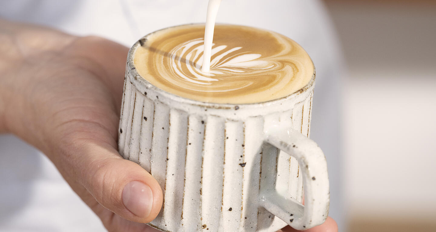 Barista odlewa serce Latte Art w filiżance Cappuccino