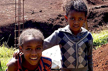 Doi copii etiopieni în fața șantierului