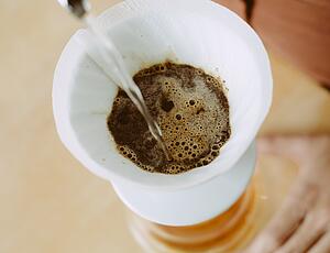 Wasser wird auf Handfilter mit Kaffee gegossen
