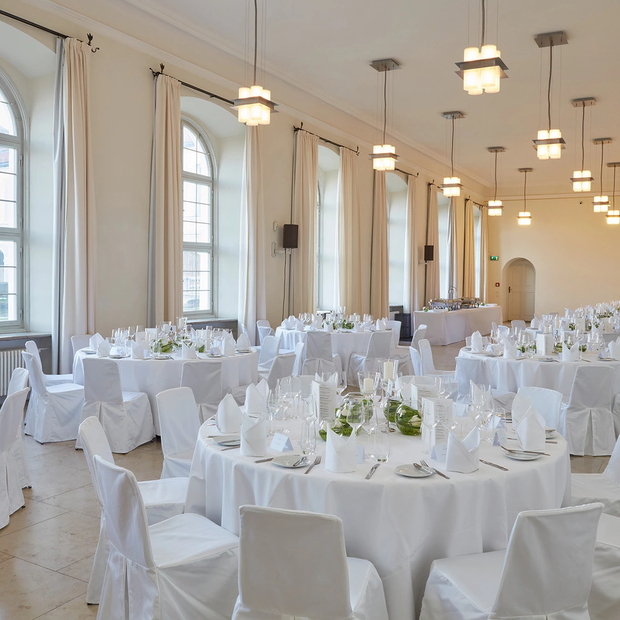 Weiß gedeckte Tische im Orangeriesaal des Schlosses Nymphenburg