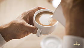 Barista gießt Latte Art Herz in Cappuccino
