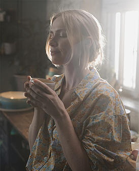 Een blonde vrouw geniet van een cappuccino