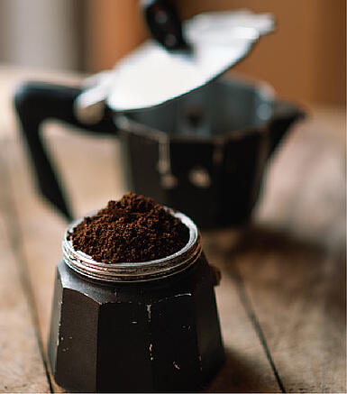 Šviežiai malti kavos milteliai espreso puodeliui filtro įdėkle