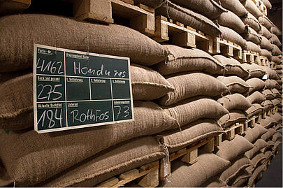 Coffee beans are stored in stacked coffee sacks