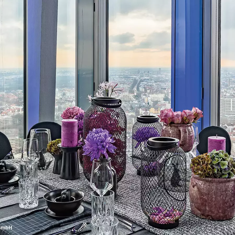 Design Büro mit lilanen Blumen und grauer Tischdekoration