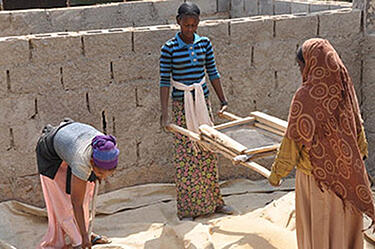 Három etióp munkás segít az építkezésen