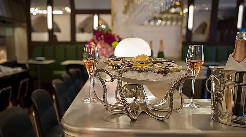 Champagnergläser und Austernplatte auf der Theke im Dallmayr Bar & Grill