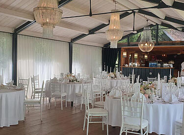 Hochzeits-Location mit weißen Tischen und Blumen Dekoration