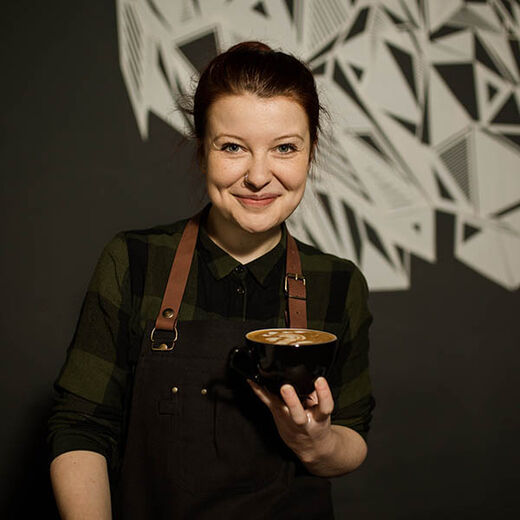 Barista June Simon präsentiert einen Cappuccino mit Latte Art