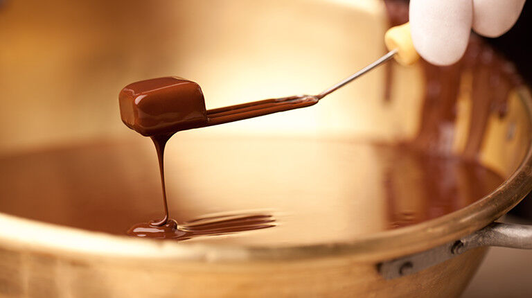 Pralinka sa vyberá z tekutej čokolády vidličkou