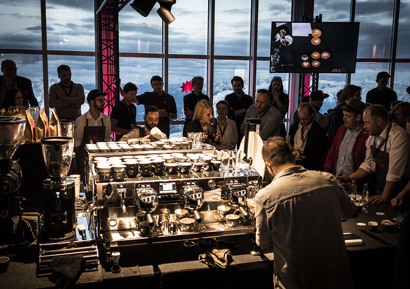 Baristi bereiten Kaffee an Siebträgermaschinen vor Publikum des Alpenbarista zu
