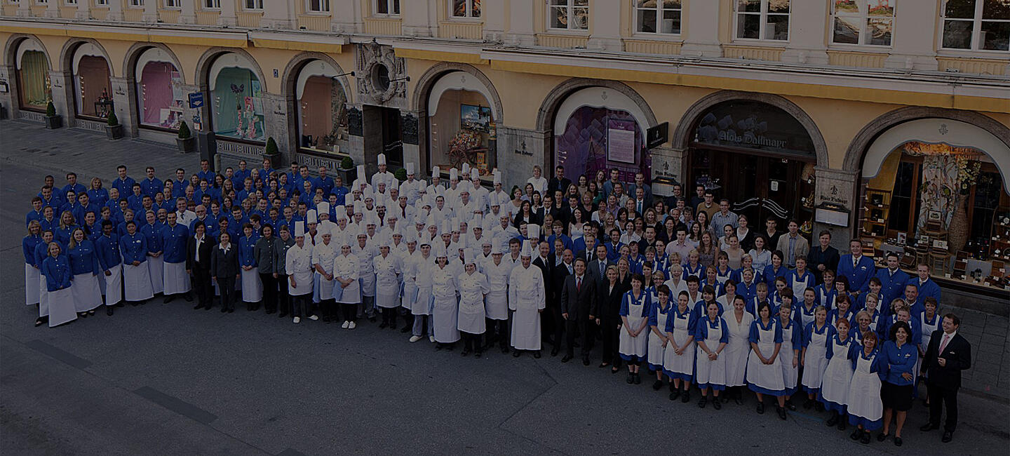 Mitarbeiter der Dallmayr Delikatessenhauses stehen vor dem Stammhaus in München