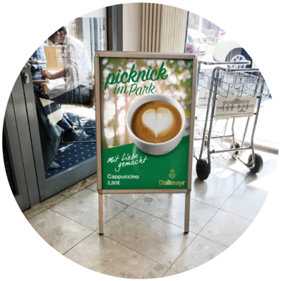 Supporto publicitario "Picnic nel parco" davanti a un caffè