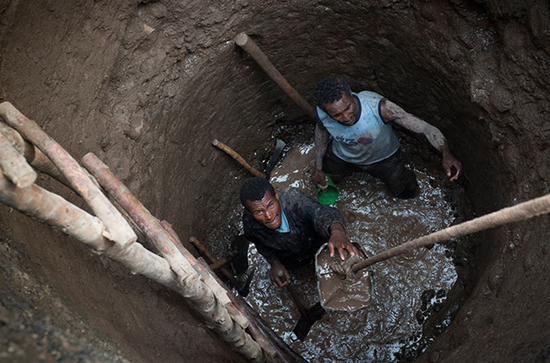 Bewohner graben ein Brunnenloch