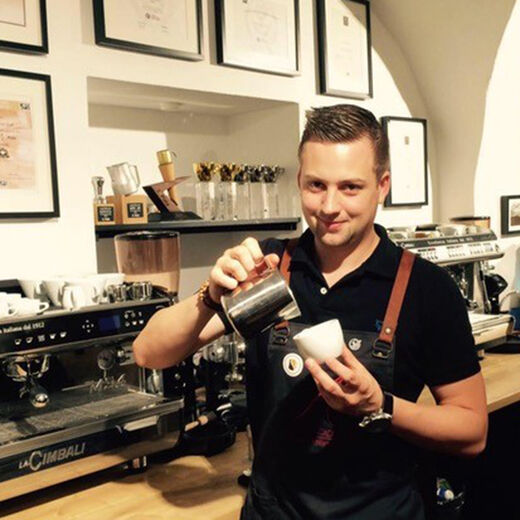 Barista Benjamin Graf gießt Latte Art in einen Cappuccino