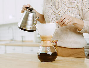 heisses Wasser wird in Chemexkanne mit Kaffeepulver gegossen