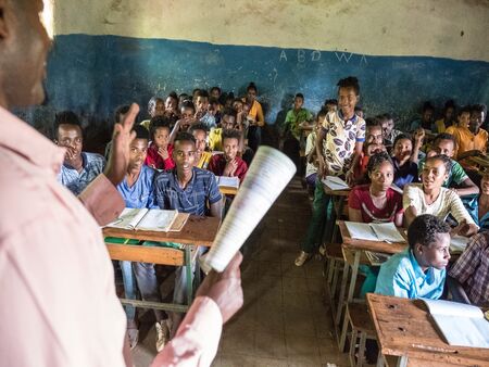A teacher stands in front of a large class of Ethiopian school pupils