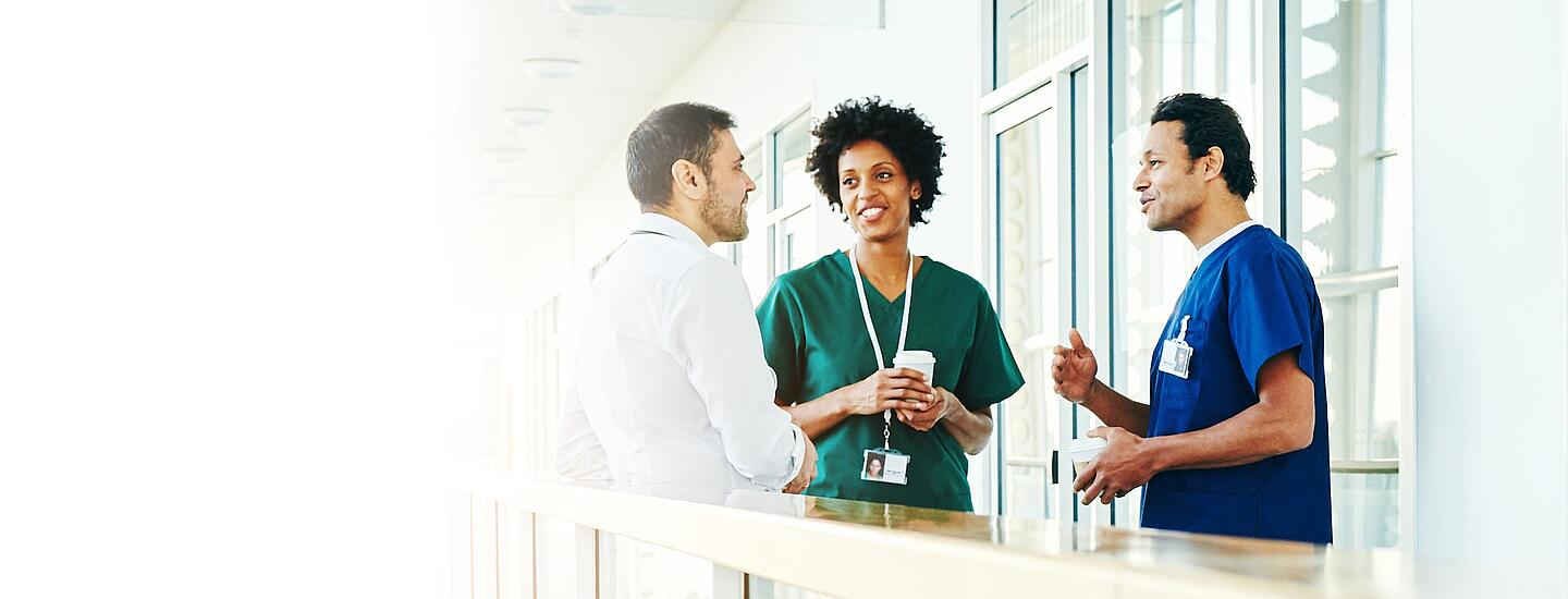 Trois employés de l'hôpital discutent dans le corridor 