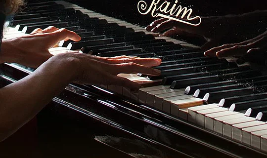 Frau spielt Dallmayr Melodie am Klavier