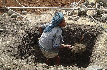 An Ethiopian worker digs foundations